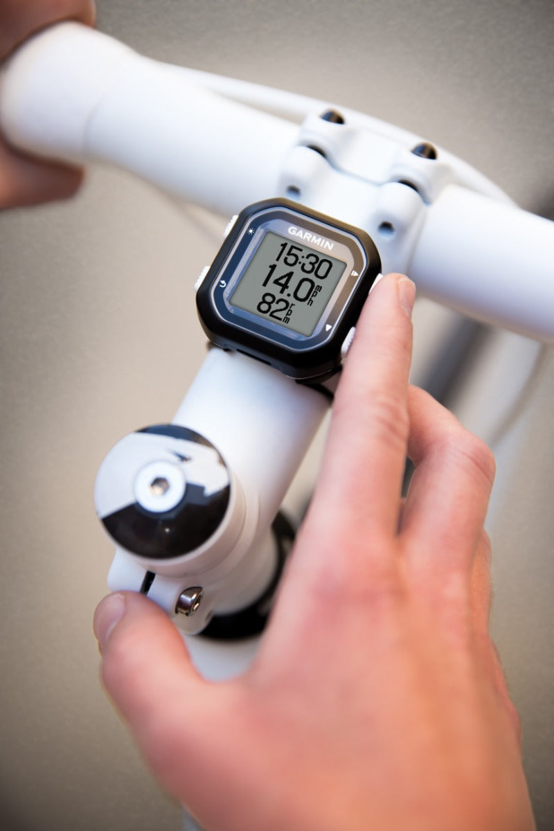 Garmin Edge 25 bike computer mounted on white handlebars; black unit with Garmin display.