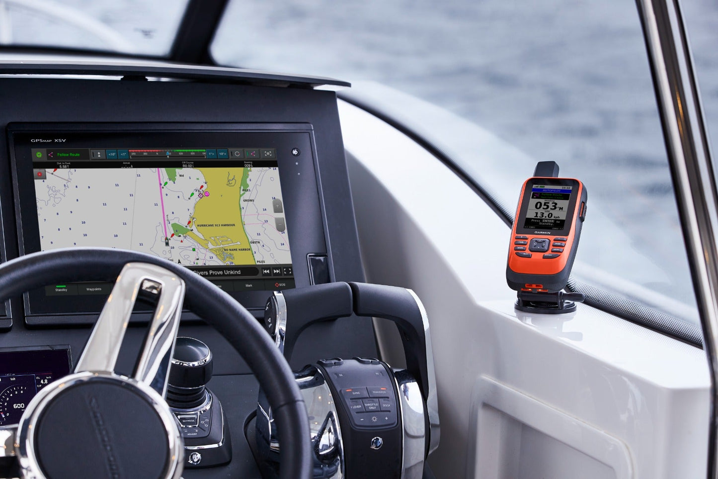 Two Garmin devices: GPSMAP 86Sci handheld marine GPS navigator, orange, refurbished; Garmin chartplotter on the dash