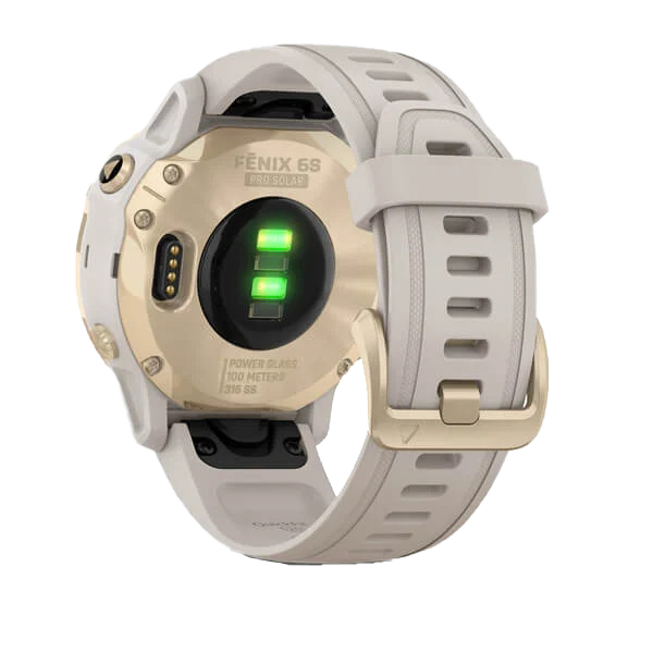 Garmin Fenix 6S Pro Solar smart watch in light gold with light sand band; rear view shows green charging contacts.